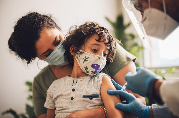 mother holding son getting vaccine