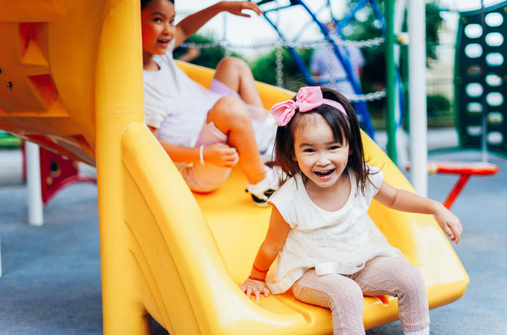 little girl on yellow slide