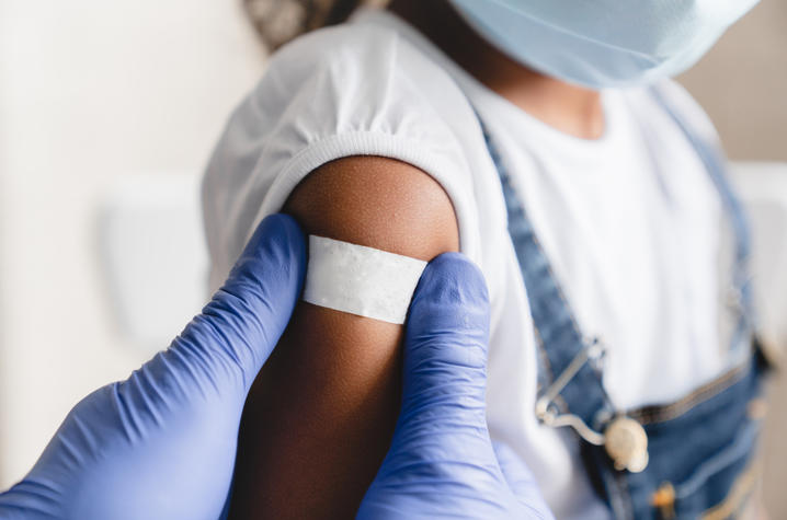 Photo of a child with a band-aid on arm after receiving a shot