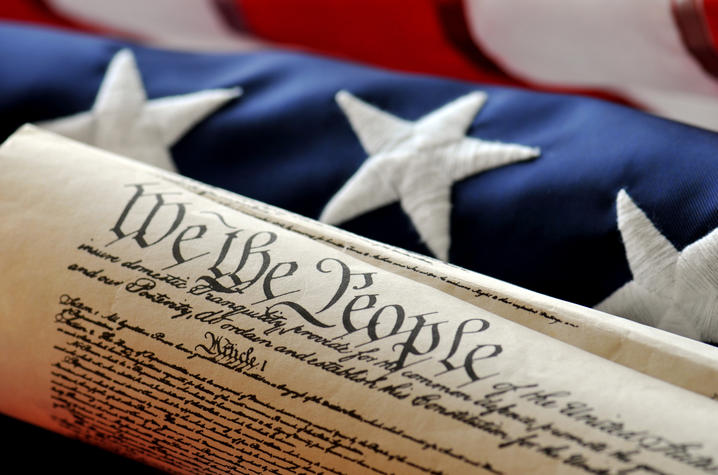 Image of U.S. Constitution in front of American flag