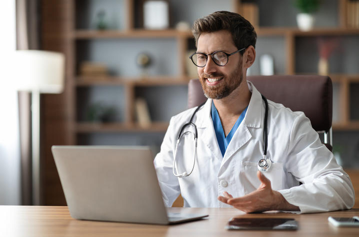 Doctor teleconferences with a patient via laptop