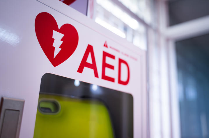 Photo of an AED An automated external defibrillator (AED) in a white box is an emergency defibrillator for people in cardiac arrest.