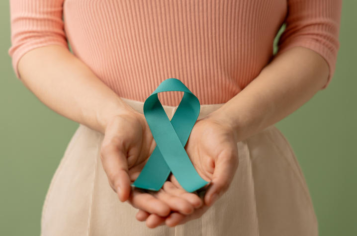 Person holding cervical cancer awareness ribbon