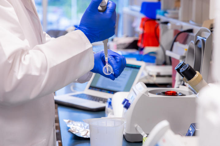 lab science a scientist in a lab is pipetting a liquid into a container
