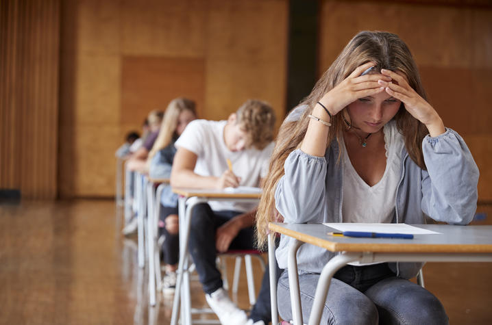 stock photo of female student with head down staring at page on desk