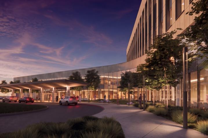 Architectural rendering of a large modern building at dusk, featuring a long glass-and-stone exterior, landscaped walkways and trees. A covered entrance with several vehicles is visible at left, while warm interior lighting glows through large windows.