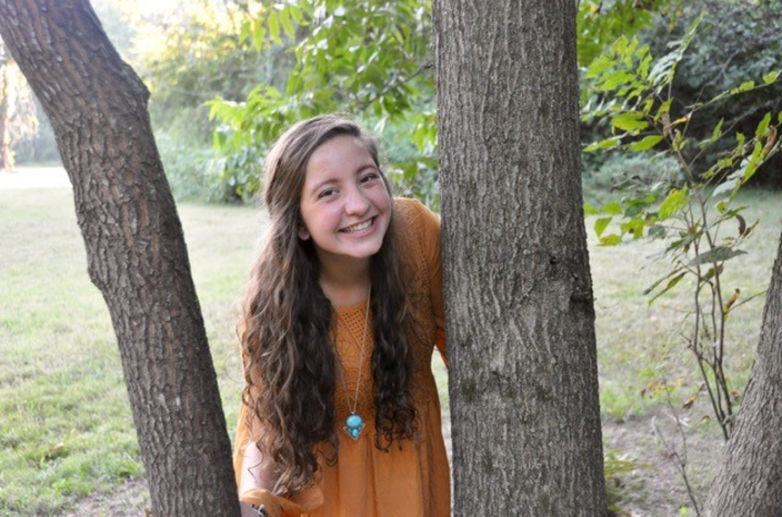 photo of Hannah Thomas posing by tree