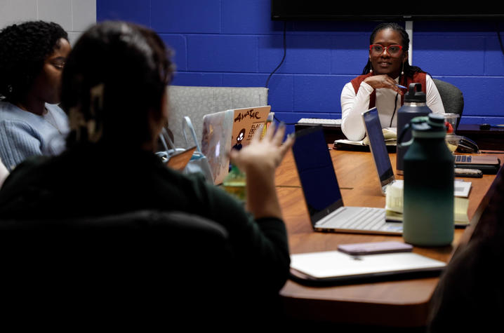 image of Dr. Hargons sitting at the head of a table listening to a student