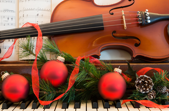 violin on a piano with garland and ornaments