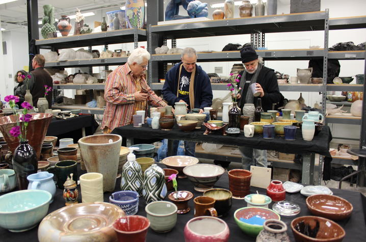 photo of people looking at ceramics in studio