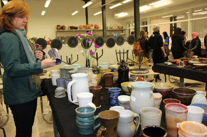 photo of lady looking at ceramic vase at ceramics sale at Open Studio 2017