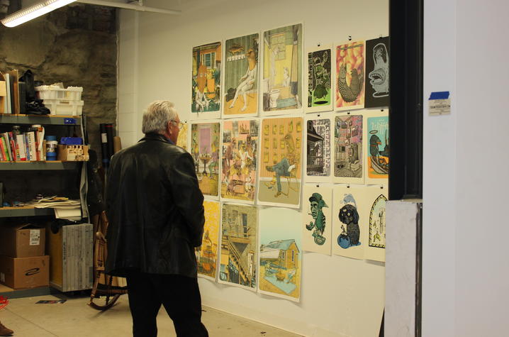 photo of man looking at art by UK student in his studio at Open Studio