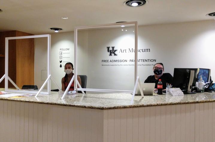 photo of UK Art Museum staff masked and seated behind plexiglass