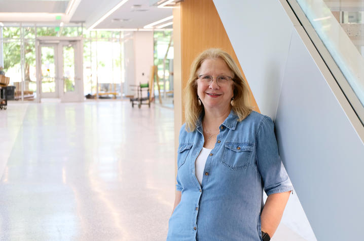 photo of Sandy Redmon in Scovell Hall A person stands beside a staircase inside Scovell Hall.