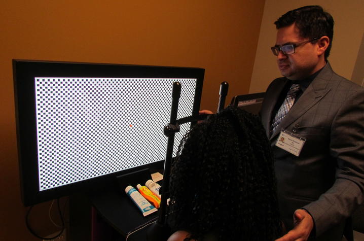 Dr. Maldonado demonstrates a vision test using lab equipment