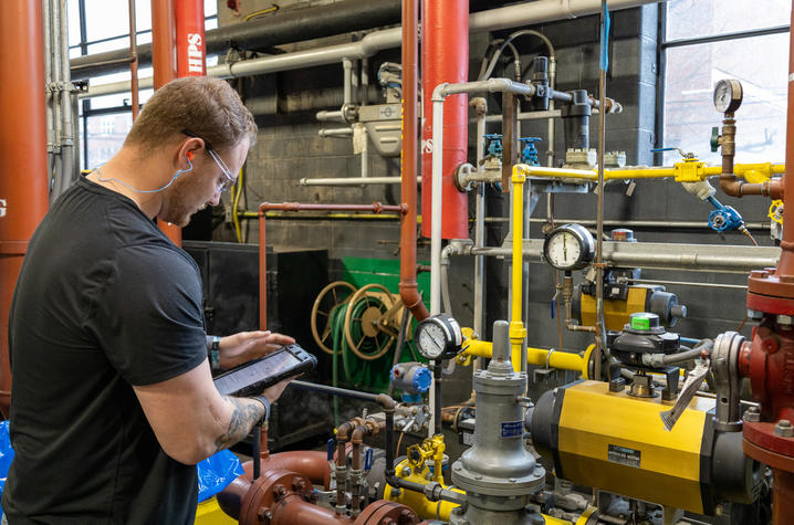 Seth DeBoard, heating/cooling operator II, conducts an hourly pressure check in the Central Heating Plant.