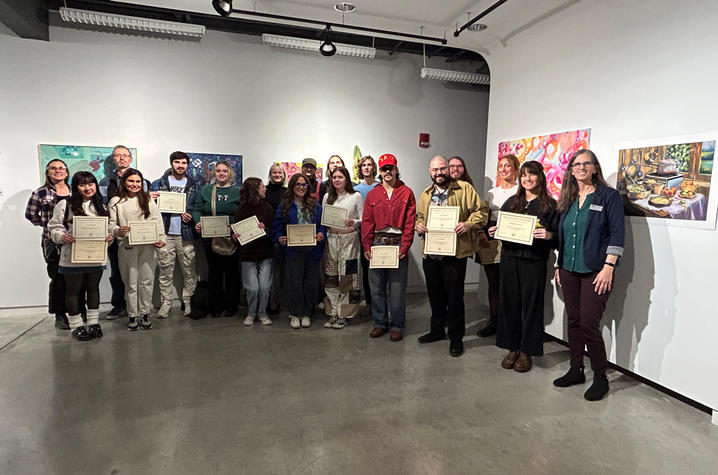 Students lined up displaying awards