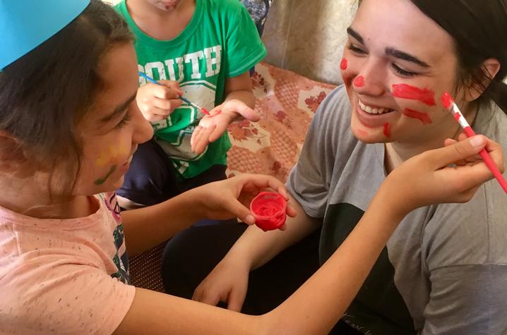 Dupler has her face painted by a student