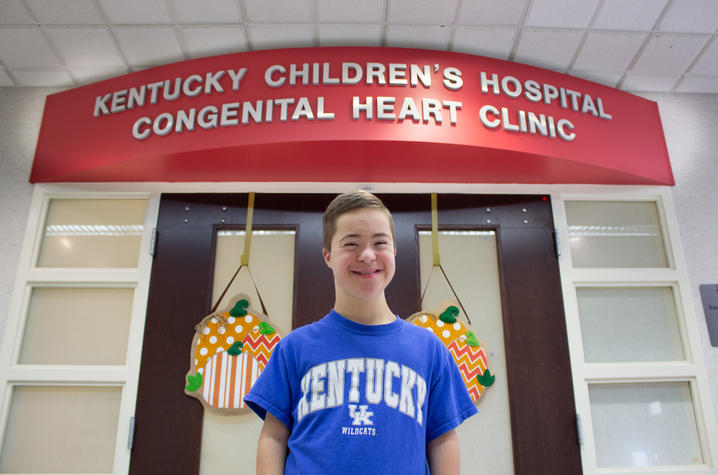 photo of jeremiah in front of the doors to the pediatric heart clinic