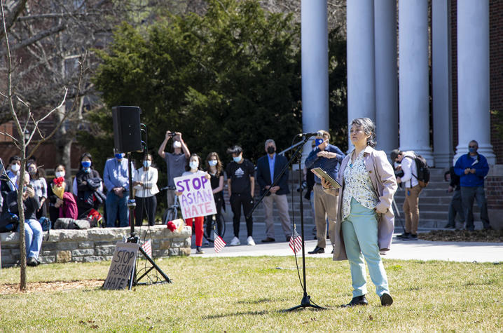 photo of Keiko Tanaka at microphone in front of Memorial Hall at the rally