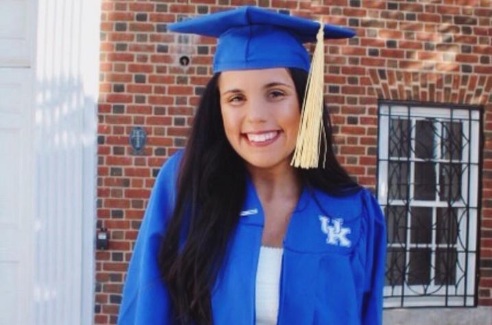 photo of Kellie Patrick in cap and gown outside Memorial Hall
