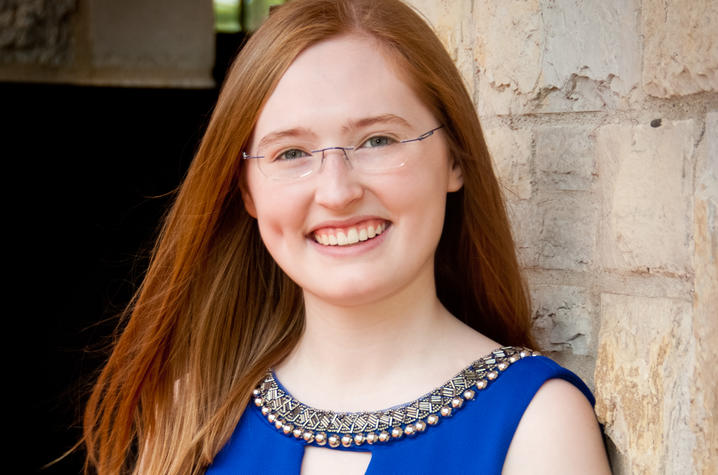 headshot photo of Kyra Seevers leaning against wall