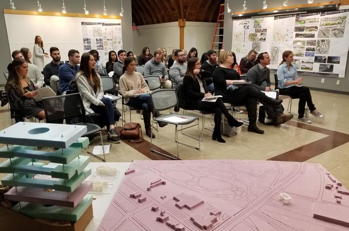 Landscape architecture crowd in chairs with design models in foreground