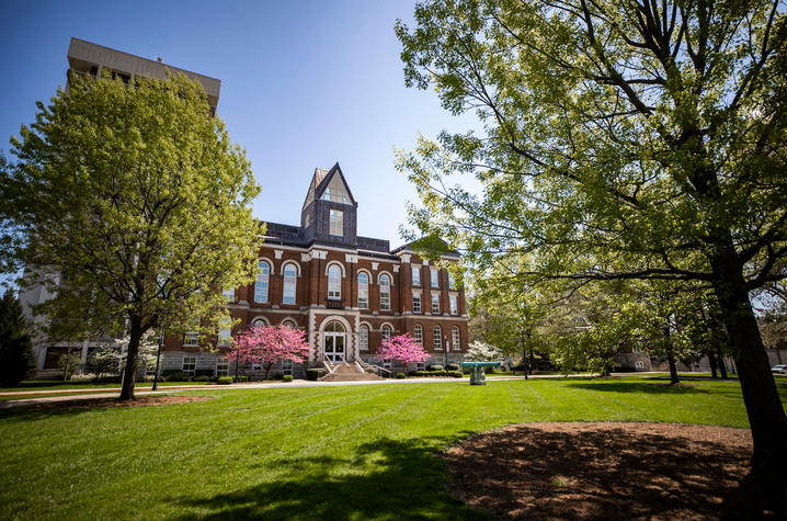 photo of Main Building from a distance through budding trees