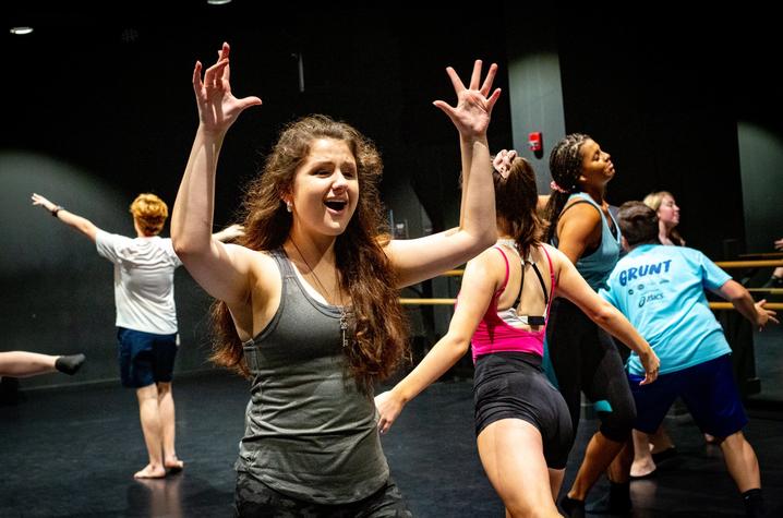 photo of GSA musical theatre students with young lady in front rehearsing