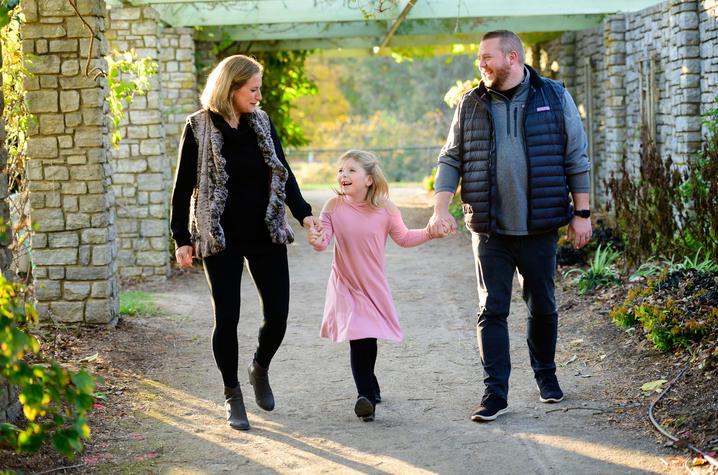 image of Sarah Beth holding hands with her parents