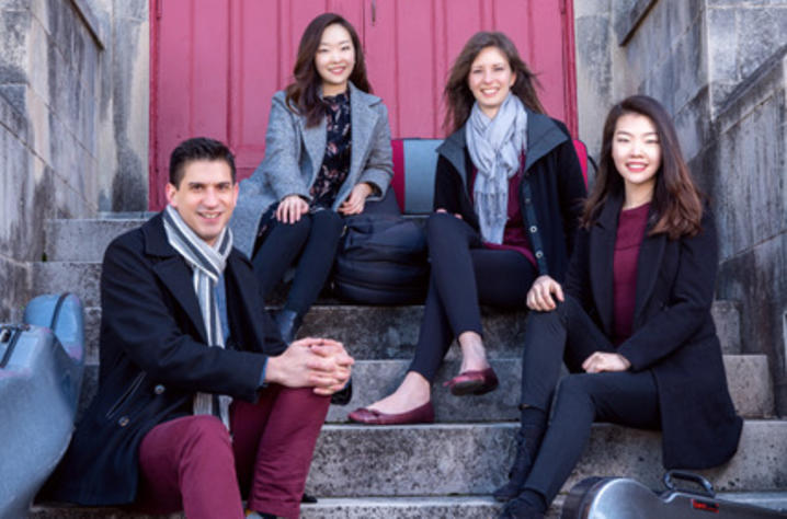 photo of Niles Quartet seated in front of red door