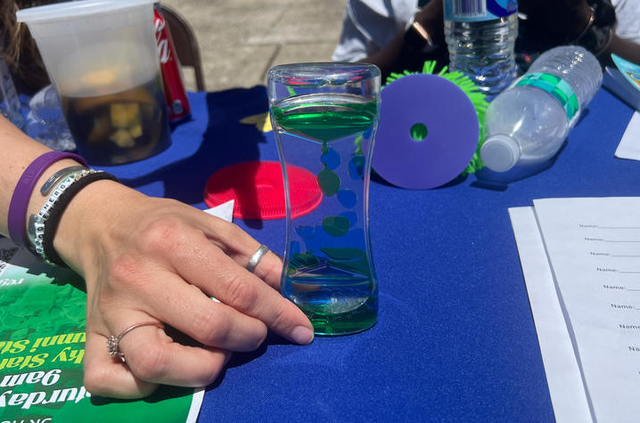 A woman holds an oil timer on a table