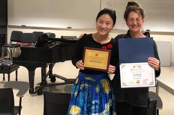 photo of Olivia-Xin Zhang and Irina Voro with awards