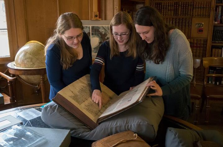 photo of Kristina Gessel, Kyra Seevers and Junior Ali Bertelsman reviewing a medieval manuscript 