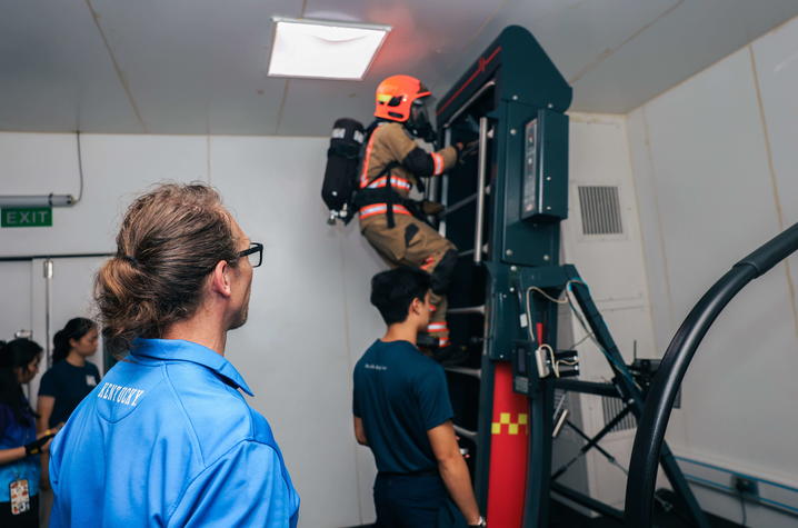 UK College of Education Department of Kinesiology and Health Promotion professor Mark Abel, Ph.D., (foreground), HTX scientists and SCDF officers at work with a SCDF firefighter during the trials. 