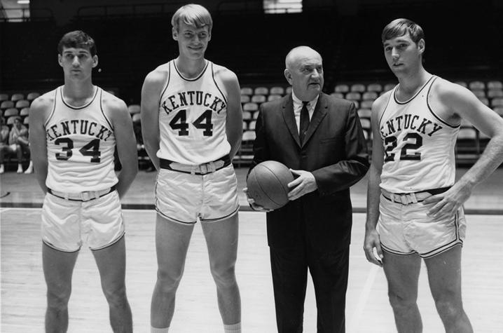 photo of Adolph Rupp (in suit) with basketball players Mike Casey, Dan Issel and Mike Pratt