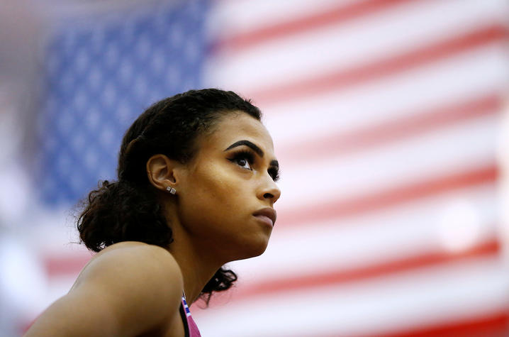 photo of Sydney McLaughlin with American flag behind her