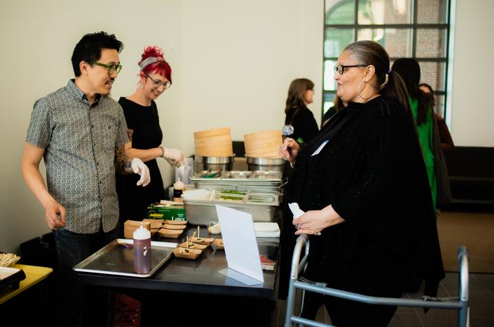 Food organizers speak with participant over table