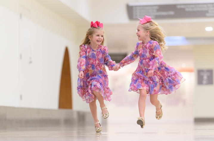 Image of twins running through the hall