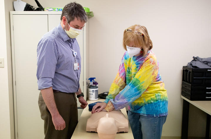 Image of Sarah performing CPR on a mannequin under the direction of Jacob Stone