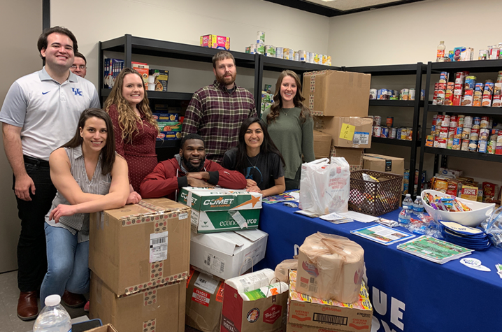 Students standing with donations at the Big Blue Pantry.