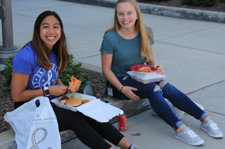 Two employees sitting down and eating. 