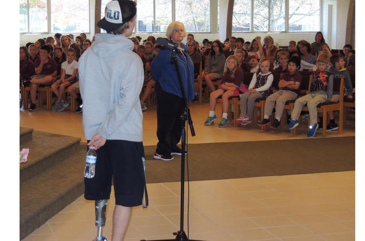 A photo of Adam Stickney, a recent amputee, speaking to elementary school students. 