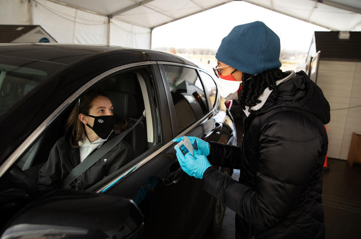 Student in a car getting ready to be tested for Covid-19 by an employee of Wild Health, UK's partner in Covid testing, in the Kroger Field drive-thru testing location.