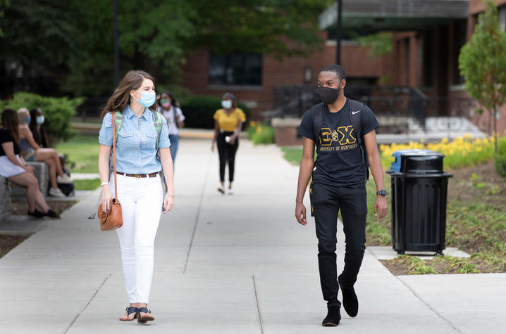 students with masks walking on campus