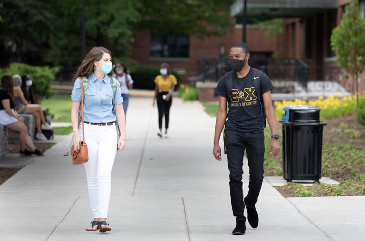 photo of students in masks walking on campus