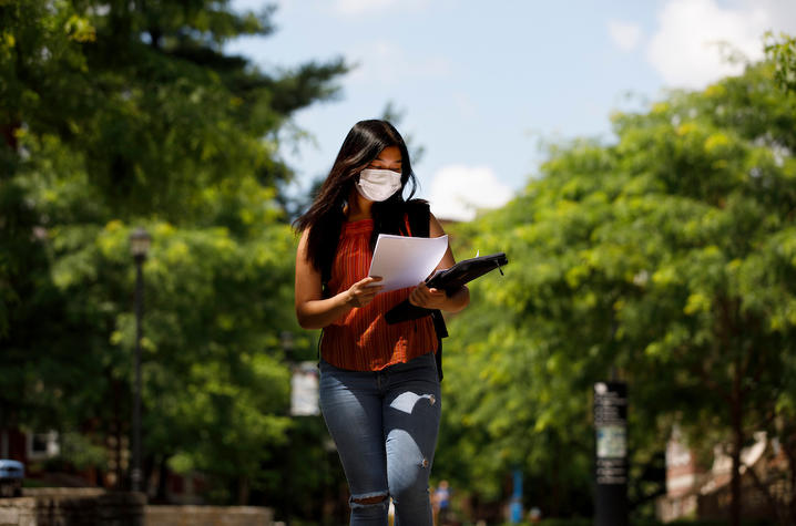 photo of student in mask walking on campus