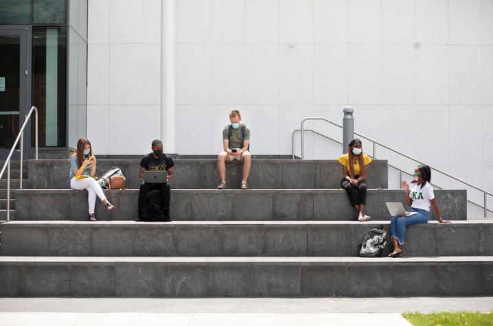 students with masks to protect from COVID-19 sitting on steps