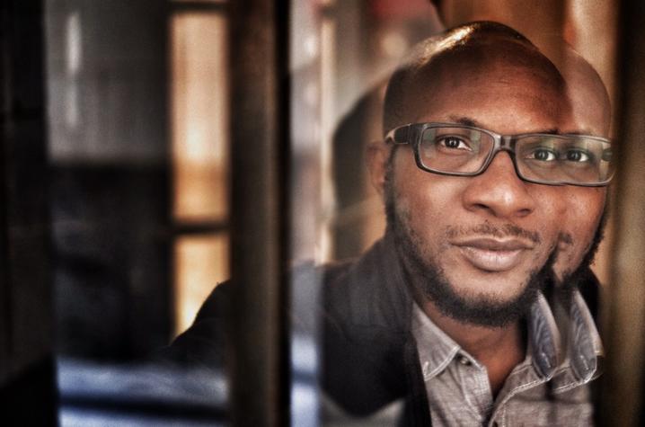 photo of Teju Cole through window panes