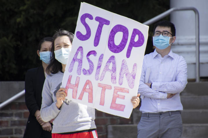 photo of rally organizer Tracy Lu with sign that says "Stop Asian Hate"
